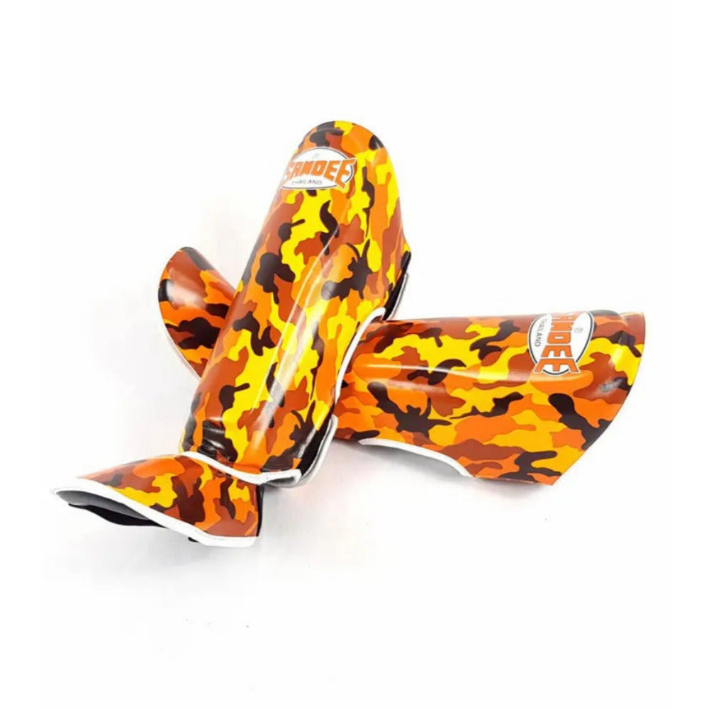 A pair of Sandee shin guards in camo orange color, designed for martial arts protection.