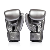 Pair of silver and black fairtex bgv1c plus microfibre boxing gloves on a white background back view of velcro closure